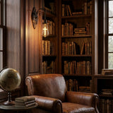 Base down cross filament LED bulb in a wall sconce above a leather armchair in a library reading nook