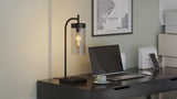 Base up cross filament LED bulb in a black desk lamp on a home office desk